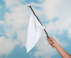 Clouds and female hand waving with a white flag to surrender